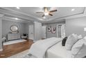 Comfortable main bedroom featuring tray ceilings, a ceiling fan, and hardwood floors at 1104 Hobson Ct, Raleigh, NC 27607