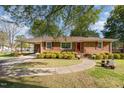 A well-maintained single-story brick home with a lush green lawn and curved sidewalk at 1108 Friendly Rd, Dunn, NC 28334