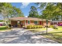 Brick home with a cozy covered carport and neat landscaping leading up to a quaint red door at 1108 Friendly Rd, Dunn, NC 28334
