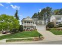 Classic two-story home with a double front porch, attached garage, and mature trees in a landscaped yard at 1113 Colonial Club Road Rd, Wake Forest, NC 27587
