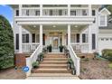 Welcoming front porch and entrance adorned with lanterns and plantings leading to a glass-paneled door at 1113 Colonial Club Road Rd, Wake Forest, NC 27587