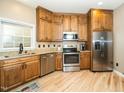 Updated kitchen boasts stainless steel appliances, light wood floors, wood cabinetry, and granite counters at 1114 Glenolden Ct, Cary, NC 27513