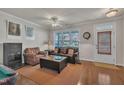 Cozy living room with hardwood floors, a ceiling fan, and ample natural light at 115 Windy Creek Ln, Apex, NC 27502