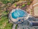 Private swimming pool with rock features, sun loungers, and a cozy outdoor seating area for ultimate relaxation at 116 Palermo Ct, Apex, NC 27539