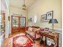 Elegant foyer with hardwood floors, a stylish settee, and a decorative rug creating a warm welcome at 119 Faison Rd, Chapel Hill, NC 27517