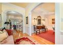 Spacious foyer featuring hardwood floors, arched doorways, and decorative wainscoting, seamlessly connecting living spaces at 119 Faison Rd, Chapel Hill, NC 27517