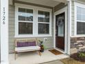 Charming front porch with bench, decorative pillows, and lovely details like a wreath and potted plants at 1726 Wimberly Rd, Apex, NC 27523