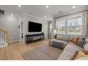 Bright living room featuring a large sectional sofa, stylish rug, and plenty of natural light at 1726 Wimberly Rd, Apex, NC 27523