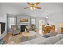 Cozy living room featuring hardwood floors, a fireplace, neutral paint, and an open floor plan at 1728 Fern Hollow Trl, Wake Forest, NC 27587