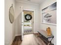 Inviting entryway with wood floors, decorative mirror, a beach photograph and a bench at 2112 Bradford Mill Ct, Apex, NC 27539