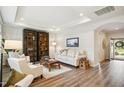 Bright living room with wood floors, recessed lighting, built-in bookcase and neutral furniture at 2112 Bradford Mill Ct, Apex, NC 27539