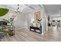 Bright office space with coffered ceilings, stylish chandelier and view of the hallway and kitchen at 2157 Blue Iris Way, Zebulon, NC 27597