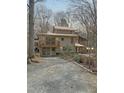 Stunning exterior elevation showcasing a multi-story home with a metal roof and a gravel driveway at 2811 Chicken Bridge Rd, Pittsboro, NC 27312