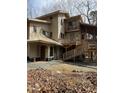 Exterior of a two-story home with multiple decks and a screened-in porch, showcasing the rear entrance and stairs at 2811 Chicken Bridge Rd, Pittsboro, NC 27312