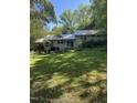 Spacious backyard featuring a lush lawn, mature trees, and a patio area with seating at 3438 Leonard St, Raleigh, NC 27607