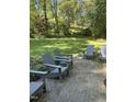 Relaxing backyard patio area with four Adirondack chairs and a well-maintained lawn at 3438 Leonard St, Raleigh, NC 27607