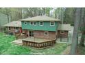 A spacious backyard featuring a wooden deck, surrounded by lush greenery and a fenced yard at 3518 Donnigale Ave, Durham, NC 27705