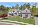 Beautiful gray home with a well-manicured lawn and mature landscaping on a sunny day at 417 Westbury Dr, Chapel Hill, NC 27516