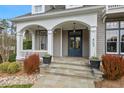 Inviting front porch with stone steps, arched entryway, and stylish hanging lanterns at 417 Westbury Dr, Chapel Hill, NC 27516