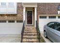 Close-up of a brick townhome entrance with dark-stained front door and a two-car garage at 452 Panorama Park Pl, Cary, NC 27519