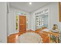 Bright foyer featuring hardwood floors, a wood front door, and views into an adjacent living space at 5109 Windance Pl, Holly Springs, NC 27540