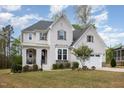 Beautiful white brick home with dark shutters, well-manicured landscaping, and a charming front porch sitting area at 5180 Glen Creek Trl, Garner, NC 27529