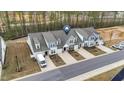 Aerial view of townhomes featuring well-kept landscaping, individual driveways, and nearby pond at 53 Whitley Ridge Dr, Clayton, NC 27527
