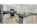 Bright kitchen featuring white cabinets, granite countertops, and stainless steel appliances, adjacent to living room at 53 Whitley Ridge Dr, Clayton, NC 27527
