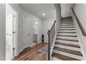Bright entryway showcasing wood floors, staircase and a convenient half bathroom at 5432 Crescent Square St, Raleigh, NC 27616