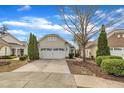Charming home featuring an attached two-car garage with a white door and beautiful, well-maintained landscaping at 563 Tomkins Loop, Cary, NC 27519