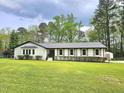 Inviting single-story home boasts a manicured lawn, complemented by neutral shutters and well-maintained landscaping at 5920 Holly Dr, Raleigh, NC 27616
