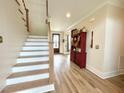 Welcoming foyer with hardwood floors and a staircase, leading to the upper level at 6521 Camellia Creek Dr, Raleigh, NC 27603
