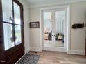 Inviting foyer with wood floors and glass French doors leading to a home office at 6521 Camellia Creek Dr, Raleigh, NC 27603