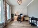 Stylish home office featuring a large window, modern lighting, and wood-look flooring at 6521 Camellia Creek Dr, Raleigh, NC 27603