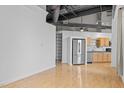 Open concept kitchen with stainless steel appliances and light wood cabinets, adjacent to a spacious living area at 700 Market St # 214, Chapel Hill, NC 27516
