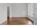 Bedroom featuring hardwood floors, white walls, natural light, and an open closet at 711 Virginia Ave, Raleigh, NC 27604