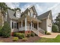 Inviting front exterior showcasing a covered porch, brick steps, and well-maintained landscaping around the property at 7252 Bedford Ridge Dr, Apex, NC 27539
