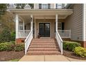 Welcoming front porch with brick steps, white railings, and a charming entrance door with sidelights at 7252 Bedford Ridge Dr, Apex, NC 27539