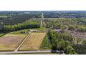 Extensive aerial view of a home and several outbuildings across a large property divided by a central road at 8079 Stone Heritage Rd, Middlesex, NC 27557