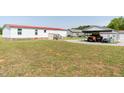 Back view of the home with a carport, a garage, and a well-maintained lawn at 8091 Stone Heritage Rd, Middlesex, NC 27557