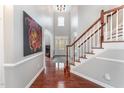 Bright foyer with hardwood floors, a staircase, and elegant architectural details at 8300 Clarks Branch Dr, Raleigh, NC 27613