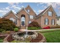 Beautiful brick home with a stone fountain and well-maintained lawn and landscaping at 9201 Club Hill Dr, Raleigh, NC 27617