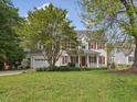 Traditional two-story home with a lush green lawn, red shutters, and a charming covered front porch at 1008 Brittley Way, Apex, NC 27502