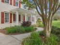 Inviting front porch with classic columns, red shutters, and landscaped walkway leading to the entrance at 1008 Brittley Way, Apex, NC 27502