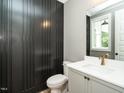 Modern bathroom with dark shiplap wall accent, white cabinets, and gold fixtures at 1029 Azalea Garden Cir, Raleigh, NC 27603