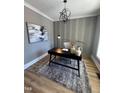 Stylish office space with gray walls, wood floors, a modern desk and decorative lighting fixtures at 1029 Azalea Garden Cir, Raleigh, NC 27603