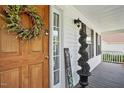 Inviting front porch featuring a wooden door, decorative wreath, and a curated welcome display at 1039 S Philwood Ct, Fuquay Varina, NC 27526