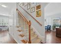 Elegant staircase with carpeted steps, wooden handrail, and gallery wall leading to the upper level at 1039 S Philwood Ct, Fuquay Varina, NC 27526