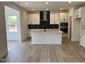 Well-equipped kitchen with stainless steel appliances, white cabinets, island, and a modern backsplash at 1140 Sun Springs Rd, Wake Forest, NC 27587