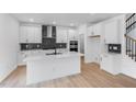 Modern white kitchen with a large island, stainless steel appliances, and stylish backsplash at 1140 Sun Springs Rd, Wake Forest, NC 27587